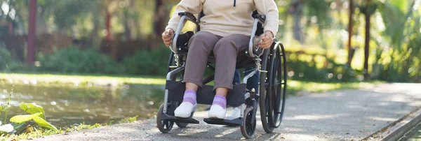 Stock image Nursing home. Young caregiver helping senior woman in wheelchair