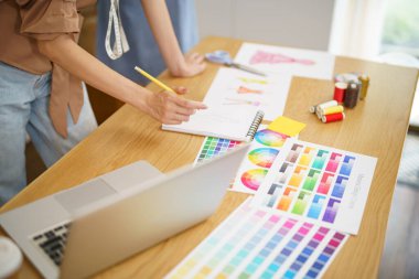 Terzide çalışan terzi kadın atölye atölyesinde moda tasarımcısı yeni bir koleksiyon tasarlıyor.