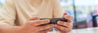 Cep telefonuyla oyun oynayan adam. Oyuncu çocuk elinde akıllı telefon, cep telefonuyla video oyunu oynuyor. cep telefonu teknolojisi e-ticaret kavramı.