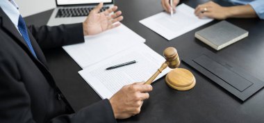 Hukuk danışmanı müvekkiline tokmak ve hukuk hukuku ile imzalanmış bir sözleşme sunar. Adalet ve avukat kavramı.