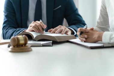 Avukat hukuk danışmanı müvekkiline tokmak ve hukuk hukuku ile imzalanmış bir sözleşme sunar. Adalet ve Avukat İş ortaklığı toplantısı