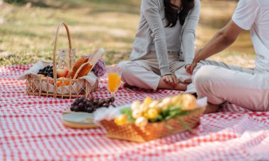 In love couple enjoying picnic time in park outdoors Picnic. happy couple relaxing together with picnic Basket.