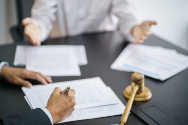 Hukuk danışmanı müvekkiline tokmak ve hukuk hukuku ile imzalanmış bir sözleşme sunar. Adalet ve avukat kavramı.