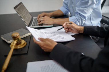 Hukuk danışmanı müvekkiline tokmak ve hukuk hukuku ile imzalanmış bir sözleşme sunar. Adalet ve avukat kavramı.