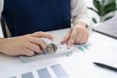 Yatırım grafiklerini analiz eden iş kadını muhasebeci ve belgelerin üzerindeki hesap makinesi tuşlarına basıyor. Muhasebe Muhasebecisi Banka Danışmanı ve Denetçi Konsepti.