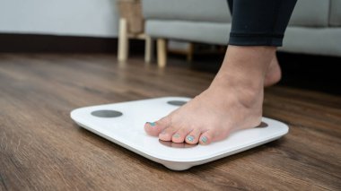 Ağırlık kontrolü için elektronik terazide duran ayaklar. Diyet kontrolü için kilogram olarak ölçüm aracı.