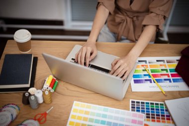 Terzide çalışan terzi kadın atölye atölyesinde moda tasarımcısı yeni bir koleksiyon tasarlıyor.