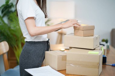 Business From Home Asian woman preparing package delivery box Shipping for shopping online. young start up small business owner at home online order.