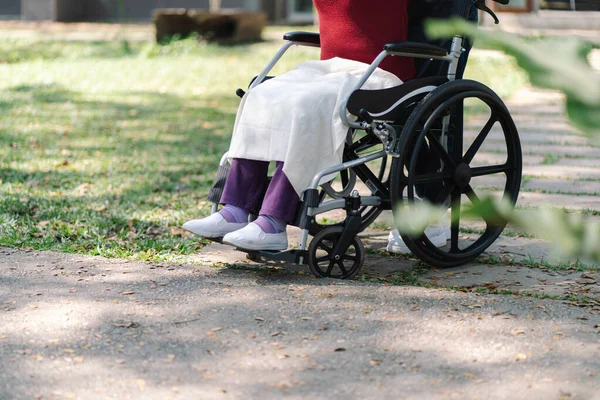 stock image Nursing home. Young caregiver helping senior woman in wheelchair