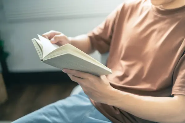 Men reading book and relaxing at home and comfort in front of opened book.