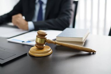 Avukat hukuk danışmanı müvekkiline tokmak ve hukuk hukuku ile imzalanmış bir sözleşme sunar. Adalet ve Avukat İş ortaklığı toplantısı konsepti