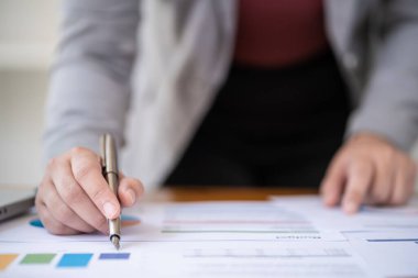 Yatırım grafiklerini analiz eden iş kadını muhasebeci ve belgelerin üzerindeki hesap makinesi tuşlarına basıyor. Muhasebe Muhasebecisi Banka Danışmanı ve Denetçi Konsepti.