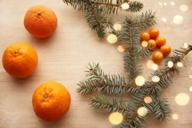 Mandalina ve böğürtlenlerle süslenmiş, hafif ahşap arka planda çelenklerle süslenmiş Firavun dalları. Yukarıdan bak. Noel konsepti. Yüksek kalite fotoğraf
