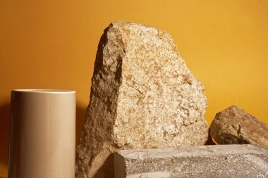 Heykel doğal malzemeden yapılmıştır. Sergiler için düzenleme. Sarı arka planda ürün sunumu için taş podyum. Yüksek kalite fotoğraf