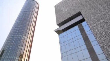 Modern mimari, yüksek binalar, şehirde gündüz gökdelenler, aynalı binaların olduğu bir video. Yüksek kaliteli FullHD görüntüler