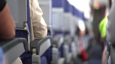 Uçağın içinde odaklanmamış bir görüntü. Yolcular koltuklarında oturuyorlar. Uçaktaki koltuklar boyunca koridorun aşağısına bak. Yüksek kalite 4k görüntü