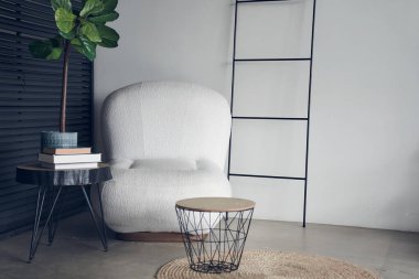 Dekoru modern tarzda. Tasarımın için bir yer. Şık bir kahve masası ve incir ağacının yanında beyaz bir koltuğu olan rahat bir oturma odasının iç tasarımı. Yüksek kalite fotoğraf