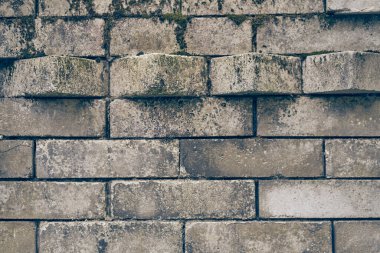 Düz olmayan yüzey eski ve kirli taş tuğlalardan yapılmıştır. Duvardan çıkan blokların çıkıntılı kısmı. Eski, yıpranmış bir tuğla. Kopyalanacak yeri olan taş dokusu. Yüksek kalite fotoğraf