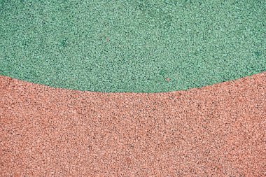 Oyun parkları için yeşil ve turuncu lastik kaplama. EPDM plastik granüller. Spor ve oyun alanlarını korumak için. Kopya alanı ile güvenlik ve yaralanma önleyici lastik gübre. Yüksek kalite fotoğraf
