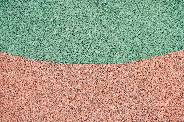 stock image Green and orange rubber coating for playgrounds. EPDM rubber granules. Covering for sports and playgrounds. Rubber mulch for safety and injury prevention with copy space. High quality photo