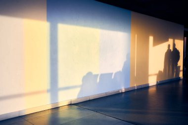 Havaalanında beyaz bir duvarda, kopyalayacak yeri olan bir adamın silueti. İnsanların bulanık gölgeleri. Yüksek kalite fotoğraf