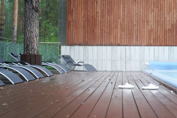 Деревянный пол из досок на фоне леса и бассейна. Утро во время праздников в загородном отеле на фоне природы. С пространством для копирования. Высокое качество фото