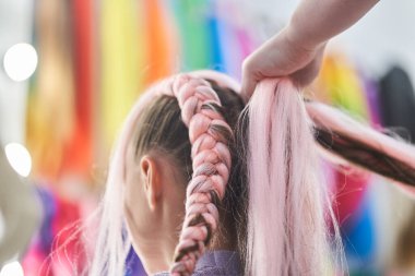 Ustalar saçlarına kanekalon dokuyorlar. Pembe kanekalondan yapılmış bir çocuk için örgü ören bir usta. Kopyalanacak bir yer var. Yüksek kalite fotoğraf