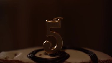 5 numaralı çikolatalı doğum günü pastası. Adamın biri pastaya mum yakıyor. Doğum günü kutlaması geleneği. Yüksek kalite 4k görüntü