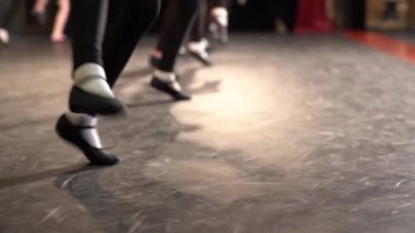 Grup dansı. Pantolon ve pantolonun içindeki kadın bacakları. Sahne kostümlerinde, pembe ışıkla aydınlatılmış yerde hafif bir tekmeyle dans ediyorlar. Yüksek kalite 4k görüntü