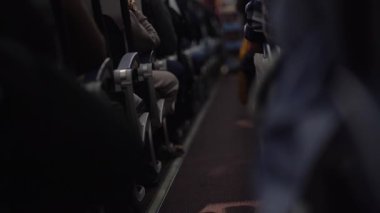 Kâhya, uçakta yiyecek ve içecek dağıtan bulanık görünüşlü bir adam. Yolcular koltuklarında oturup izliyorlar. Sıranın sonuna bak. Yüksek kalite 4k görüntü