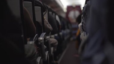 Uçakta yiyecek ve içecek dağıtan bir erkek kahyanın bulanık görüntüsü. Yolcular koltuklarında oturup izliyorlar. Sıranın sonuna bak. Yüksek kalite 4k görüntü