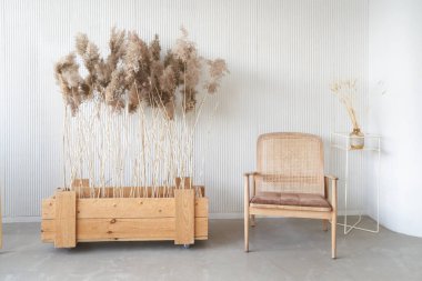 Yerdeki tahta bir kutuda kurumuş çiçekler. Pencereden gün ışığı. İç mekanda minimalizm. Kopyalamak için yer var. Tasarımın için bir yer. Yüksek kalite fotoğraf