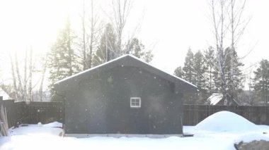 Kışın kar yağarken, arka bahçedeki karların içinde ev şeklinde kare bir hamam. Sağlıklı bir yaşam tarzı. Yüksek kalite 4k görüntü