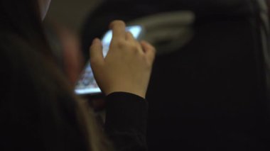Kız elinde bir akıllı telefon tutuyordu. Telefonuyla oynuyor, sosyal medyada geziniyor. Uçakta rahatlama konsepti. Yüksek kalite 4k görüntü
