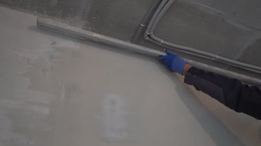 Duvarların tavana yakın hizalanması. Ev tadilatı. Daire tadilatı. Ellerinde inşaat metal kuralı olan erkekler koruyucu eldivenler giyer. Yüksek kalite 4k görüntü