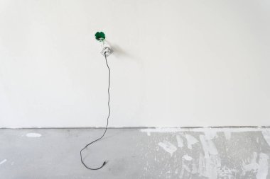 Elektrik prizi, beyaz bir duvarın arkasında telefon şarjı. Teknoloji kavramı. Kopyalayacak yer de var. Yüksek kalite fotoğraf