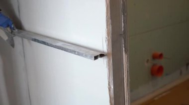 Metal bir kural kullanarak duvardaki alçıyı düzleştiriyorum. İnşaatçı apartmanın duvarına beton havan topu yapıştırıyor. Yüksek kalite 4k görüntü