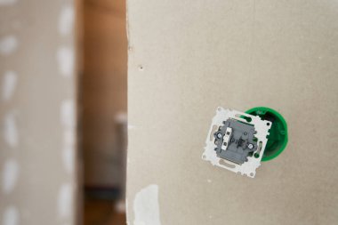 Dairenin duvarına elektrik kabloları takılı bitmemiş bir elektrik prizi. Yüksek kalite fotoğraf