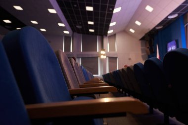 Tavanda boş mavi sandalyeler ve kare lambalarla dolu modern bir konferans odası. Kopyalayacak yer de var. Yüksek kalite fotoğraf