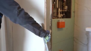 Sıvacı, metal bir spatula kullanarak duvardaki alçı tabakasını düzleştiriyor. Tadilat ve inşaat kavramı. Yüksek kalite 4k görüntü