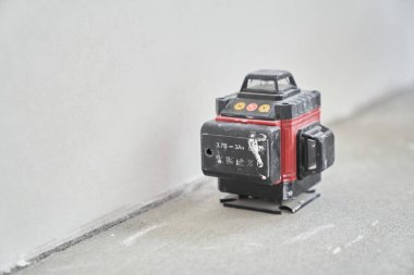 İnşaat alanındaki bir evin çıplak beton duvarında lazer seviyesinde bitirme işi için lazer donanımı. Yüksek kalite fotoğraf