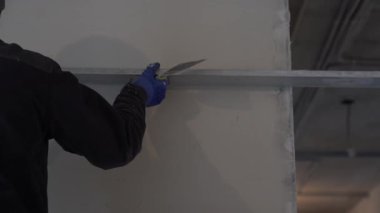 Duvardaki alçı tabakasını metal bir spatulayla düzleştiriyorum. Tadilat ve inşaat kavramı. Yüksek kalite 4k görüntü