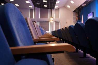 Tavanda boş mavi sandalyeler ve kare lambalarla dolu bir konferans odası. Kopyalayacak yer de var. Yüksek kalite fotoğraf