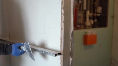 Sıvacı tamir ve inşaat kurallarını kullanarak duvardaki alçı tabakasını düzleştiriyor. Yüksek kalite 4k görüntü
