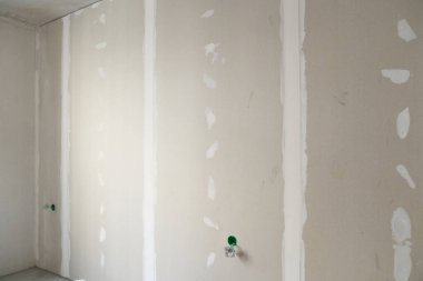 Tavan alçıpandan yapılmıştır. Kısmen sıvanmış yüzey. Priz kurulumuna hazırlanılıyor. Kopyalanacak alanı olan bir arkaplan. Yüksek kalite fotoğraf