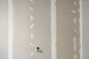 Odaları ayırmak için alçıpan duvar. Kısmen sıvanmış yüzey. Priz kurulumuna hazırlanılıyor. Kopyalanacak alanı olan bir arkaplan. Yüksek kalite fotoğraf