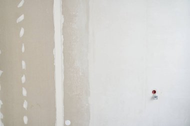 Duvar kısmen sıvanmış, alçıpandan yapılmış. Priz kurulumuna hazırlanılıyor. Kopyalanacak alanı olan bir arkaplan. Yüksek kalite fotoğraf