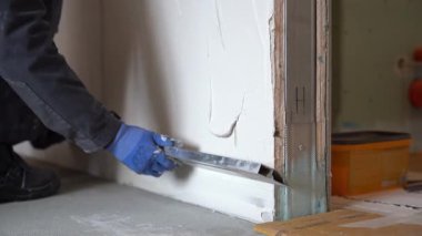 Erkek bir sıva ustası, elinde kural denilen metal bir cetvel tutuyor ve yeni sıvanmış bir duvarı hizalıyor. Yüksek kalite 4k görüntü