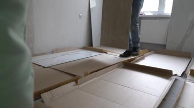 Tamir için hazırlanıyorum. Sanatçılar, fayansın duvardaki deseni seçiyorlar. Duvarlarda 120 'ye 60 inçlik geniş formatlı porselen seramikler açılıyor. Yüksek kalite 4k görüntü