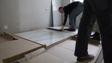 Sanatçılar, fayansın duvardaki deseni seçiyorlar. Duvarlarda 120 'ye 60 inçlik geniş formatlı porselen seramikler açılıyor. Yüksek kalite 4k görüntü